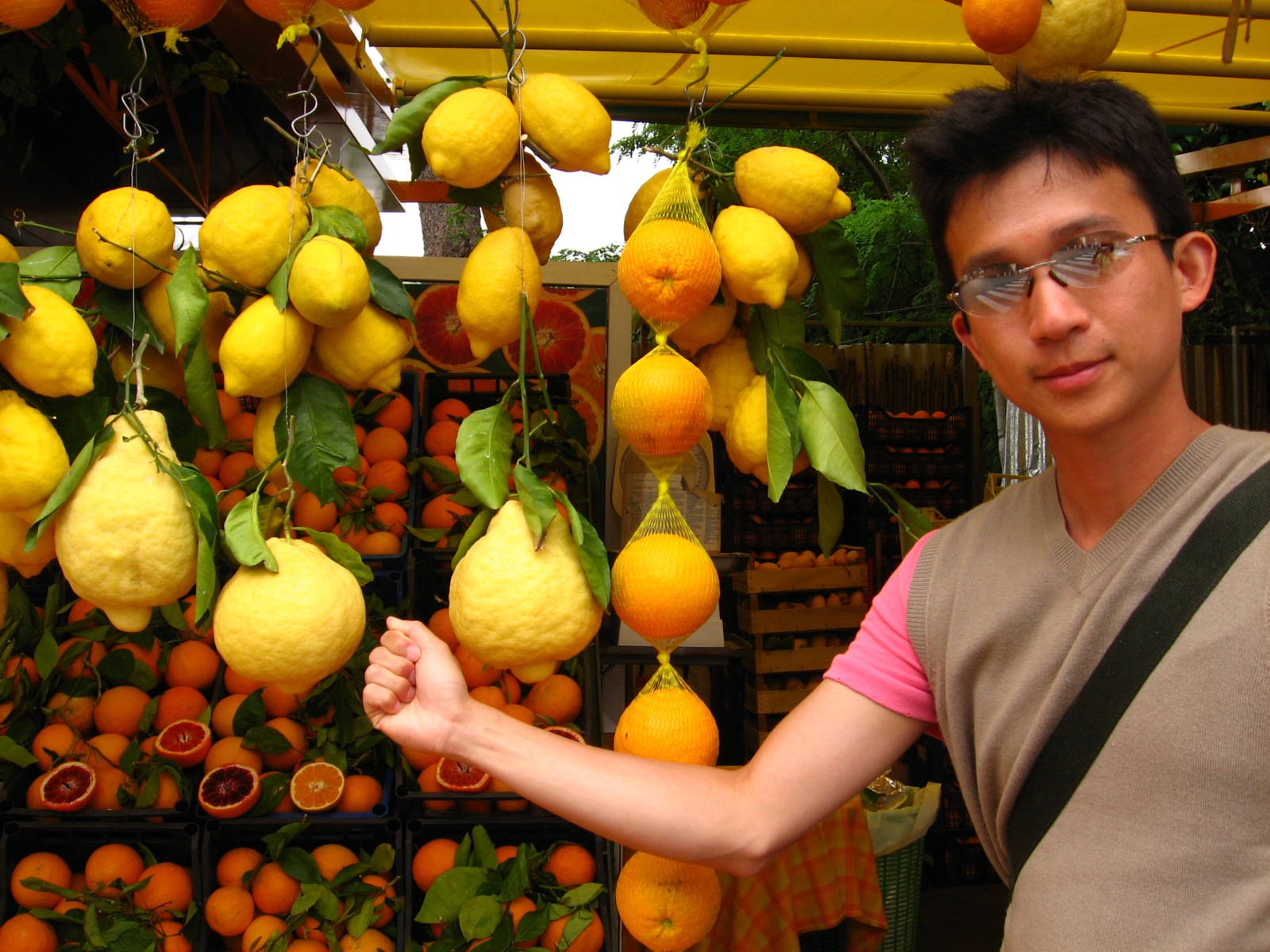 a man standing next to a display of oranges