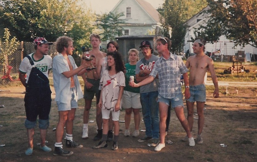 people standing in a group in a yard holding drinks