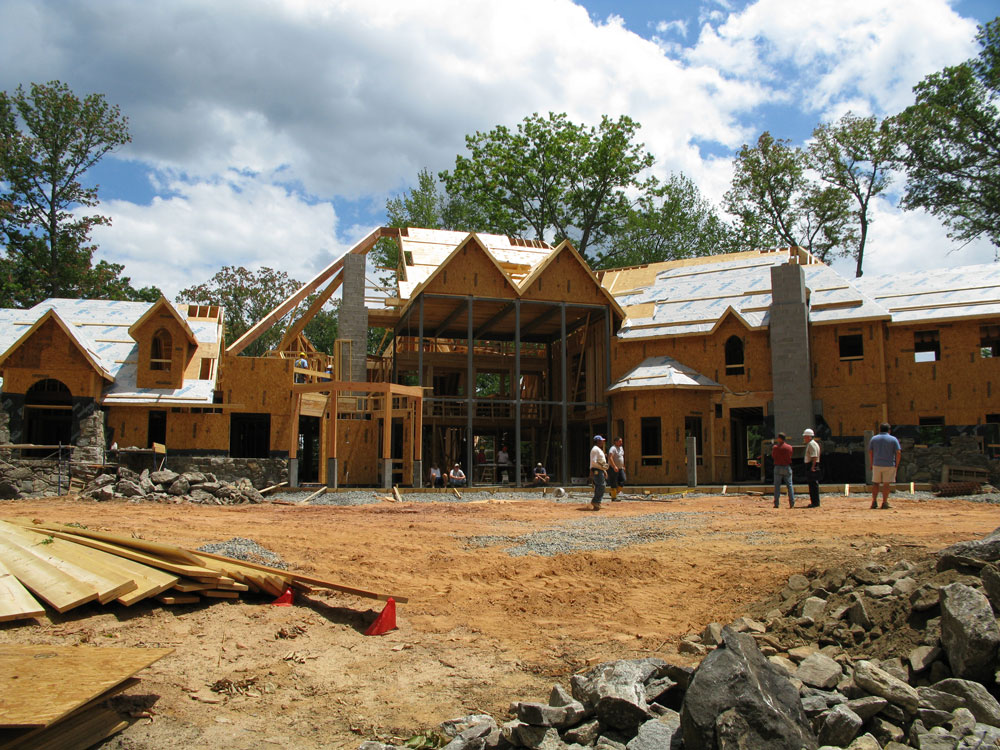 a house under construction in progress with workers around it