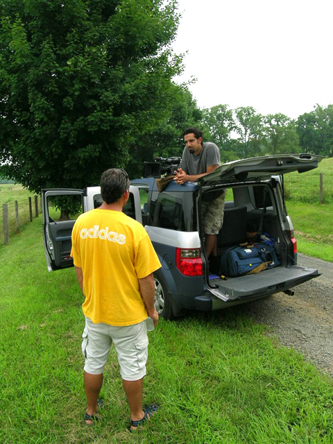 two men are loading luggage into the back of a truck