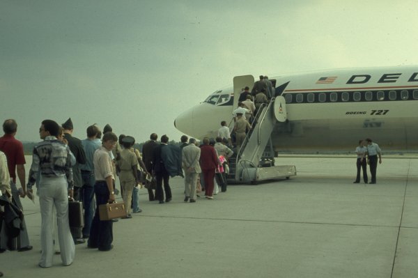 several people boarding a small commercial airliner