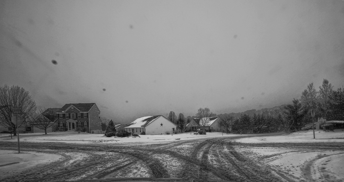 a black and white picture of a snow covered street