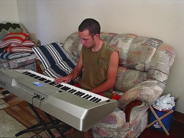 a man sitting in a chair next to an electric keyboard