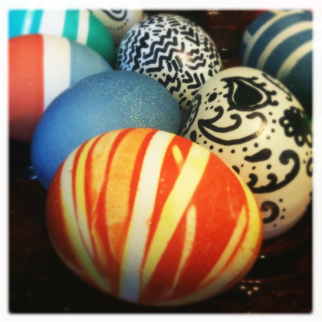 a pile of assorted colored decorated eggs