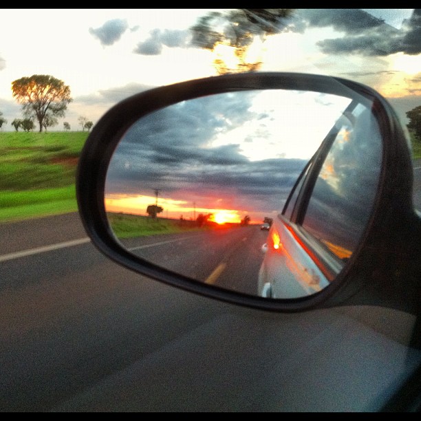 the side mirror of a car looking in the rear view mirror