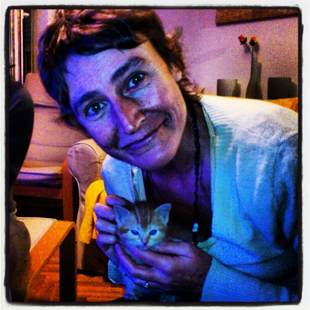 a man holding a cat in his hands and smiling at the camera
