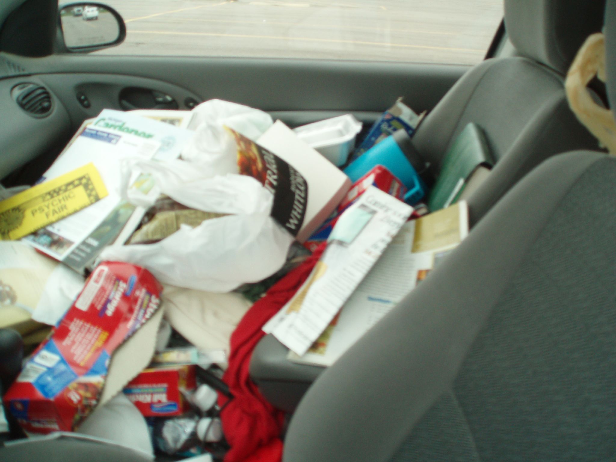 a trash bag filled with various items inside a car