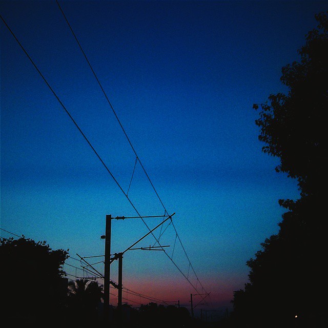 power lines and telephone poles at dusk on the street