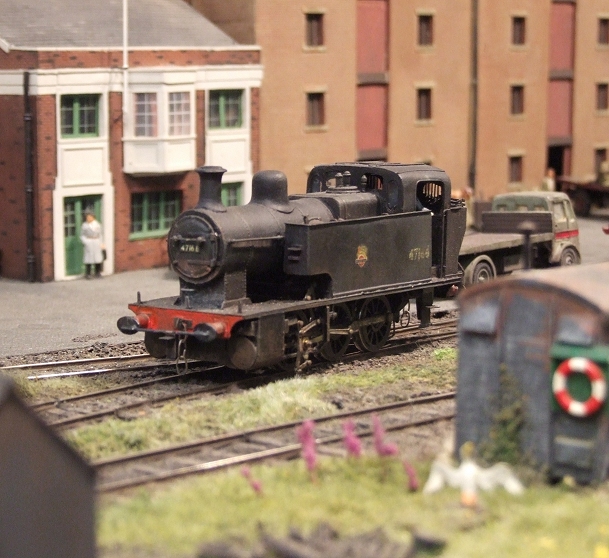 an antique model train traveling along a small town