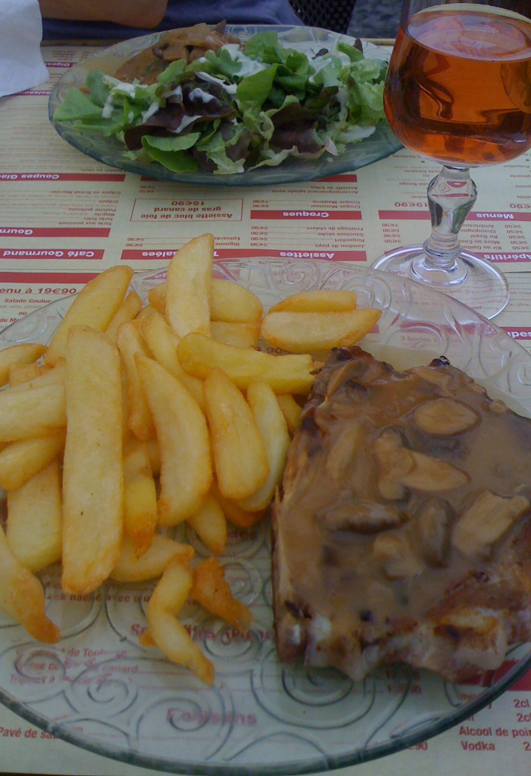 a glass plate with french fries and a plate full of food