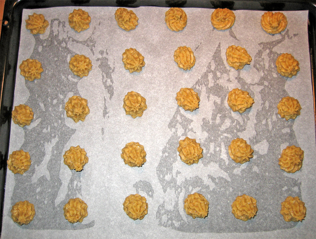 a table filled with cookies on top of a sheet of baking paper