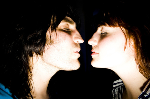 a young man and woman have noses close to one another