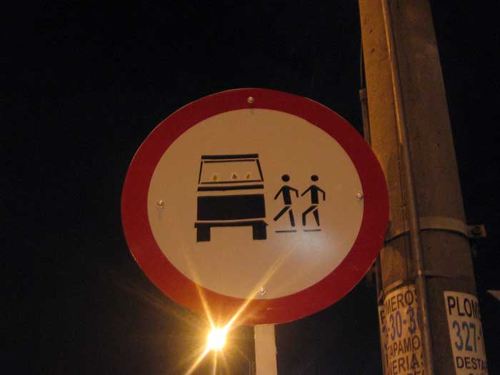 a traffic sign in a city by a street light