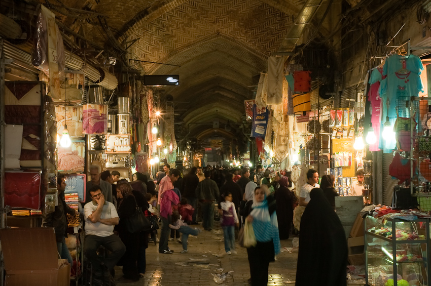 a crowded market street filled with people looking at items