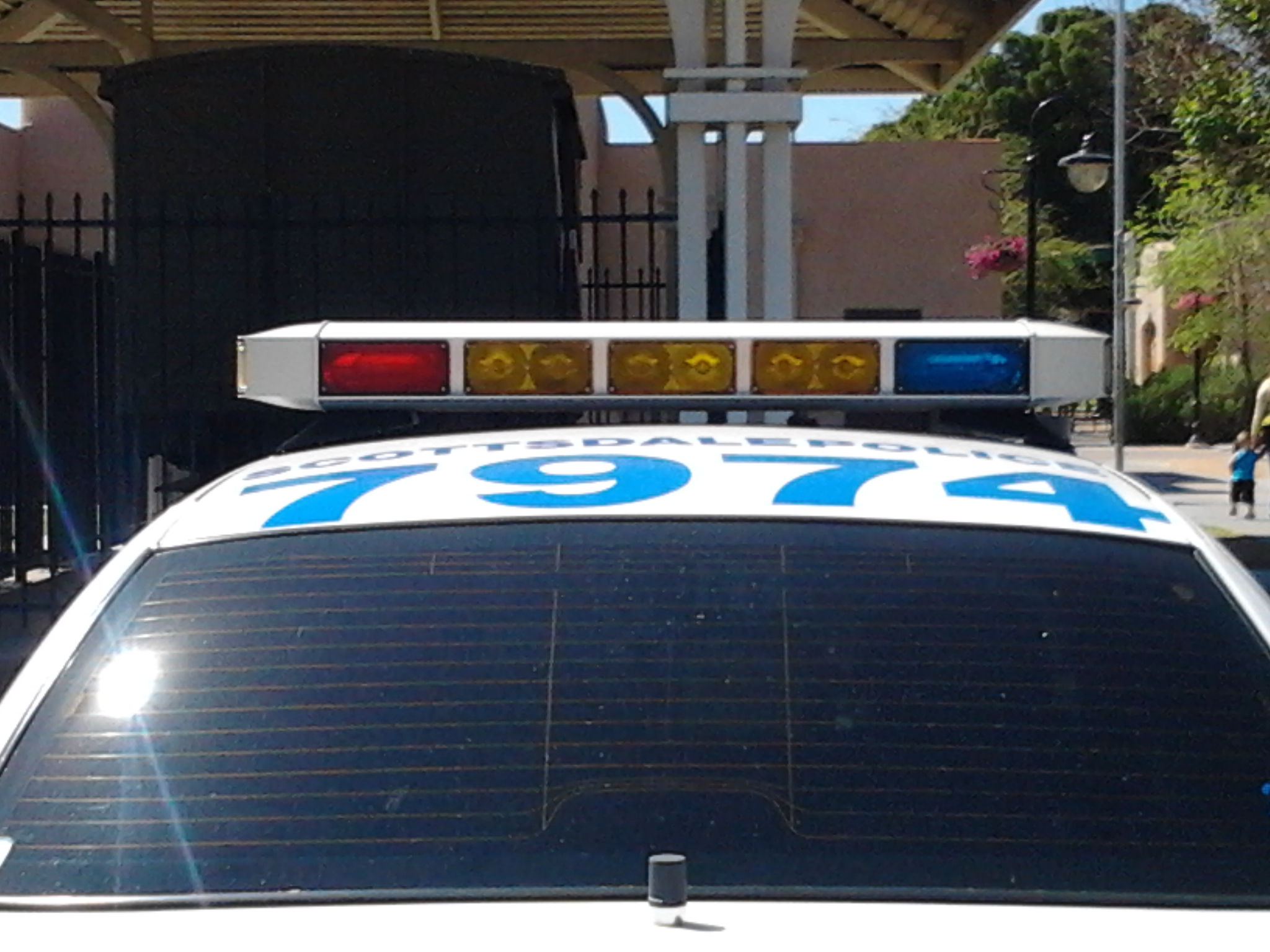 a police car parked in front of a fence