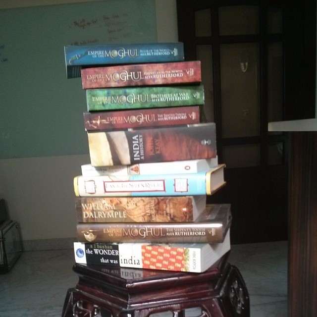 a tall stack of books sitting on top of a wooden table