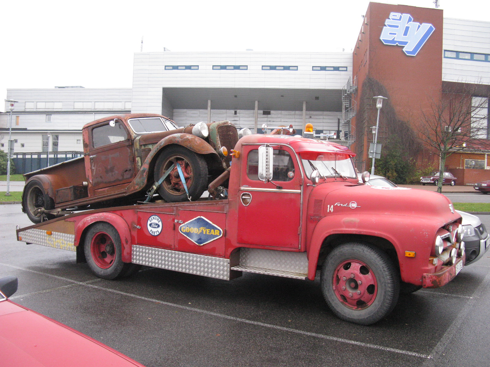 an old classic truck with a broken down car on the back