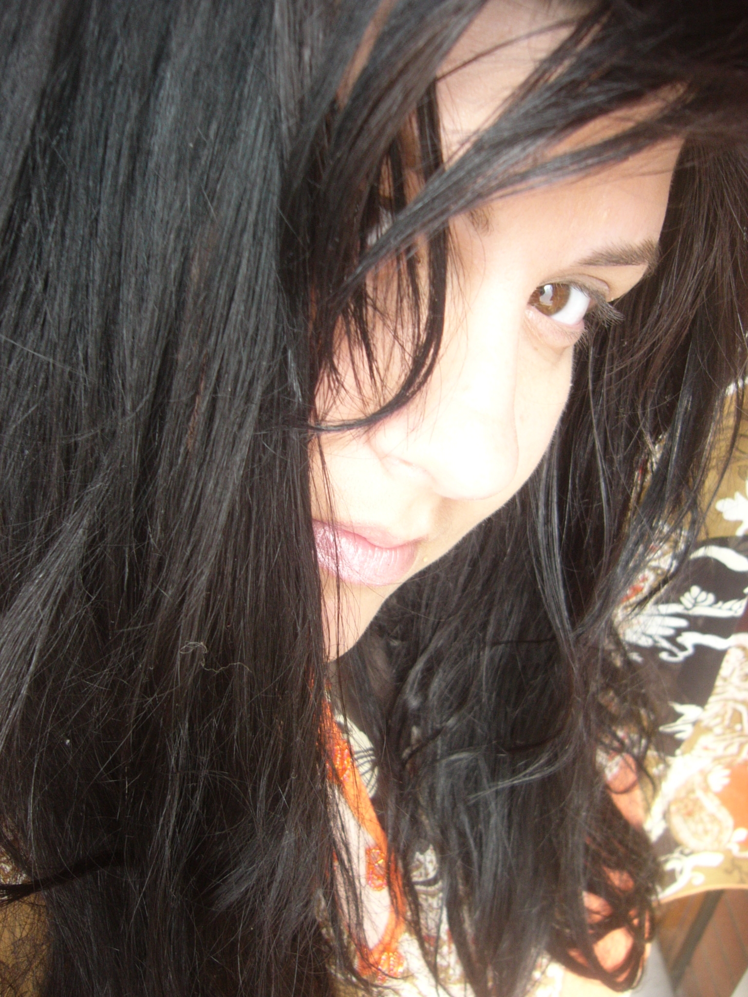 a girl with long black hair posing for the camera