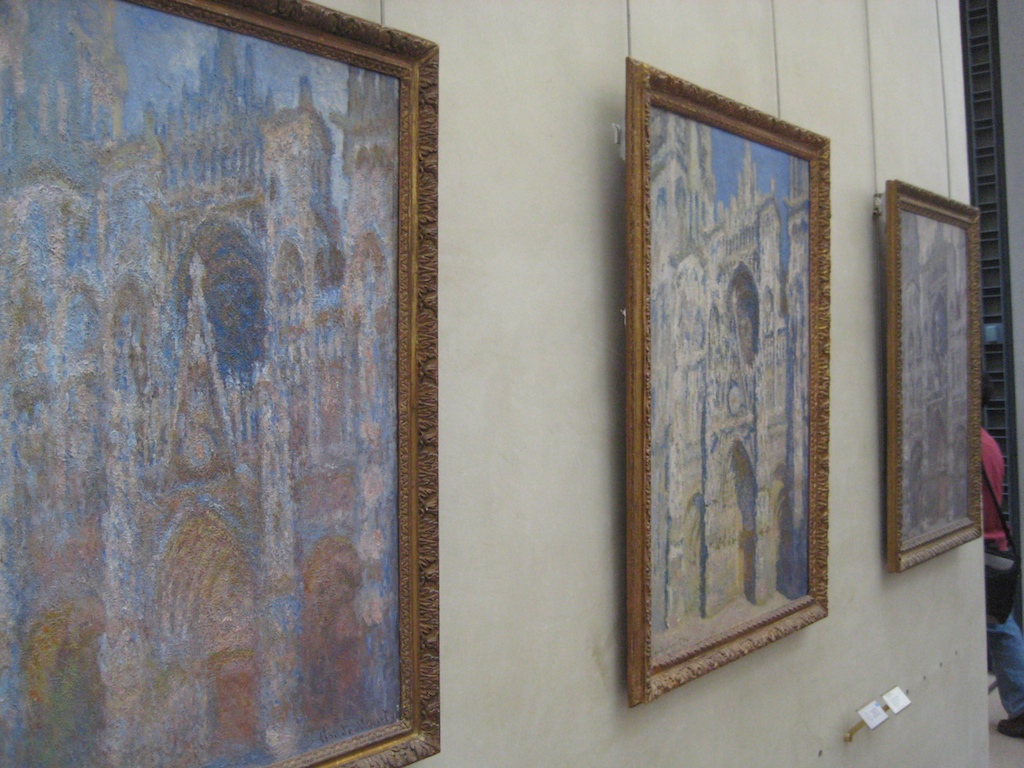 paintings hung on a wall with a price tag in front