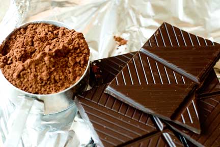 chocolates and a bucket of cocoa are on aluminum foil