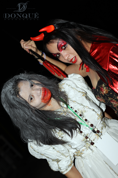two women pose as red demonic makeup on their faces
