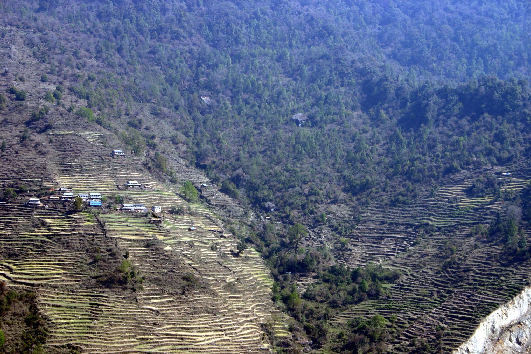 an aerial view of a small village near a mountainous area