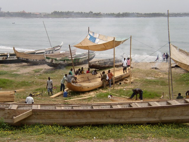 a group of men work on an antique ship
