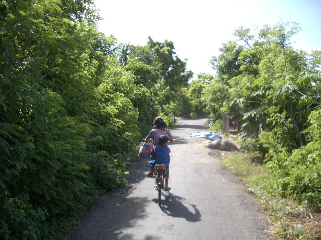 a  riding a bicycle on a paved path