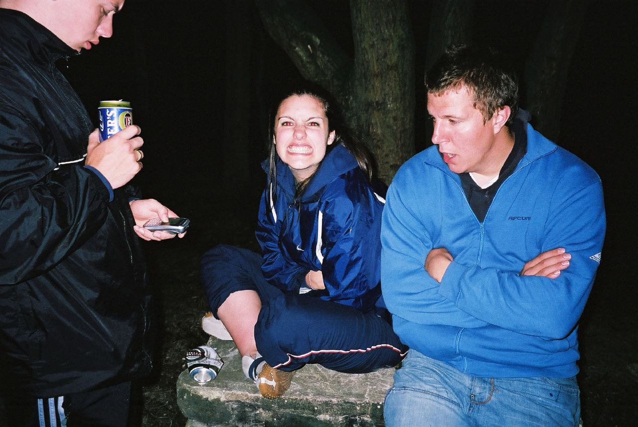 three people sitting on a stone step having a conversation