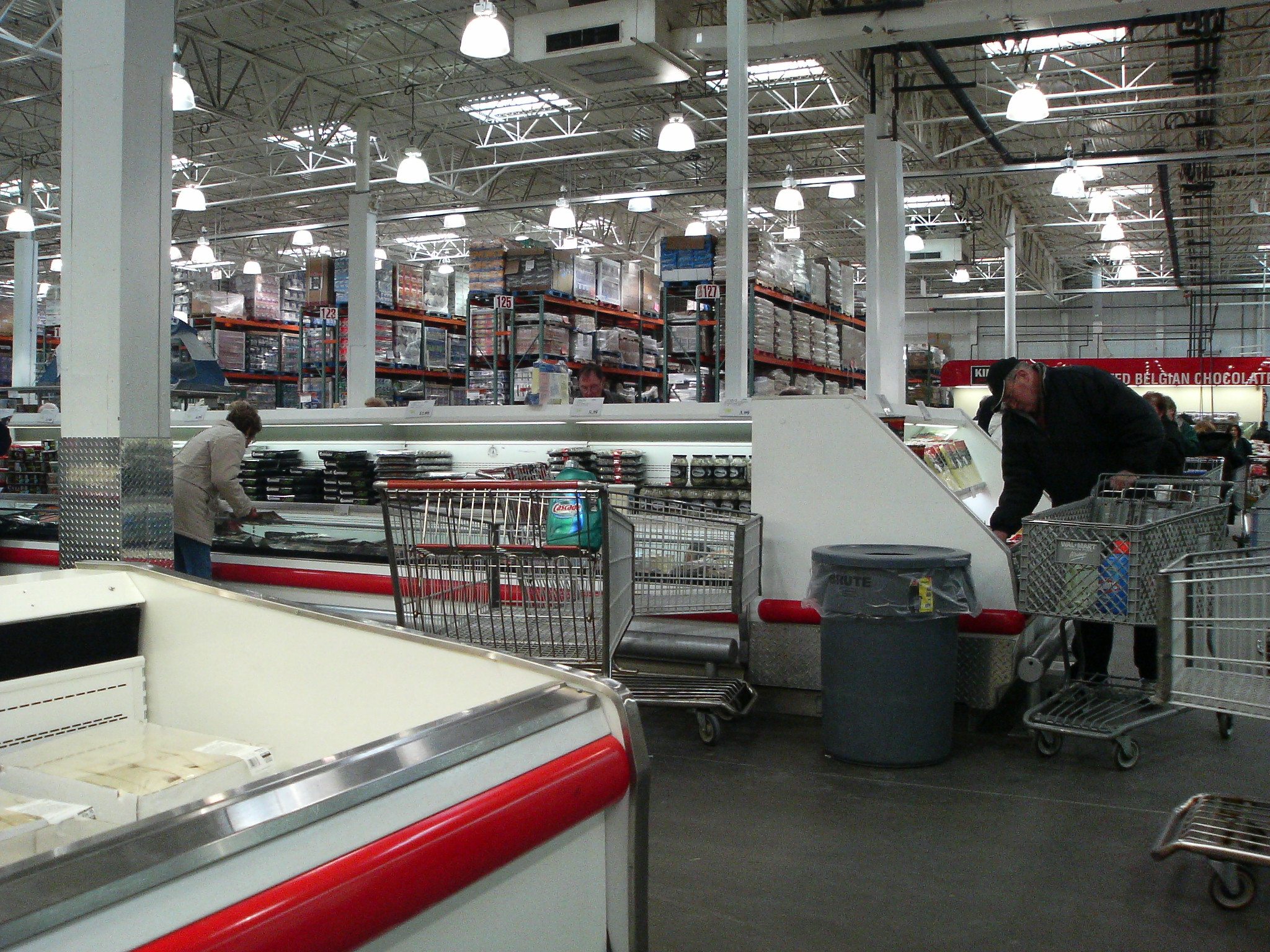 people working in a large warehouse filled with shelves
