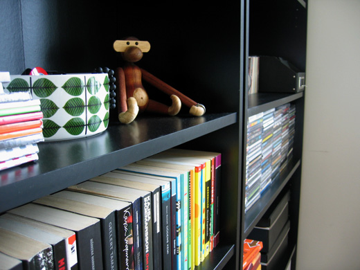 books and a monkey stuffed animal sit on the shelf
