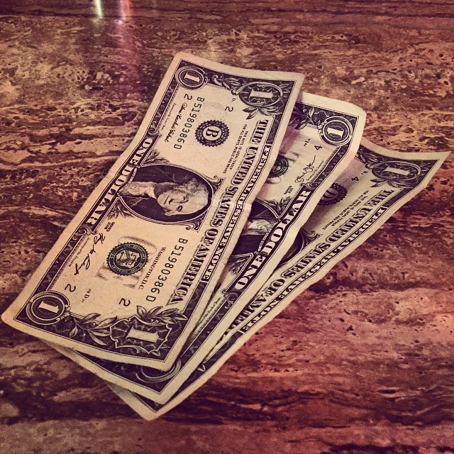 three bills laying on top of each other on a table