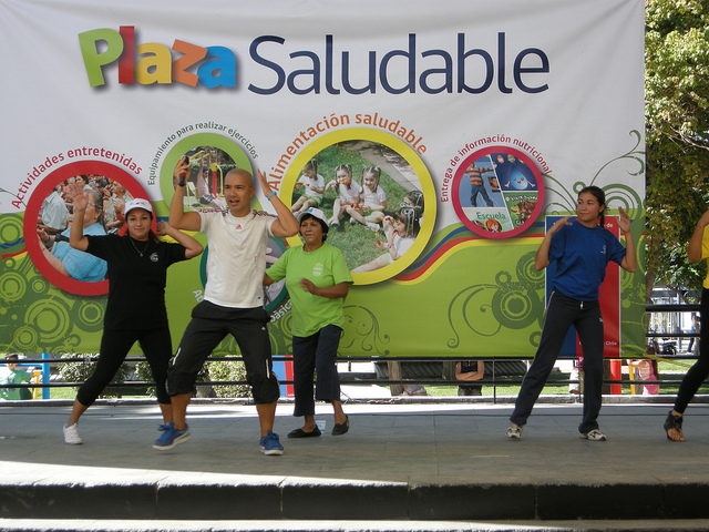 a group of people dancing in front of a large banner