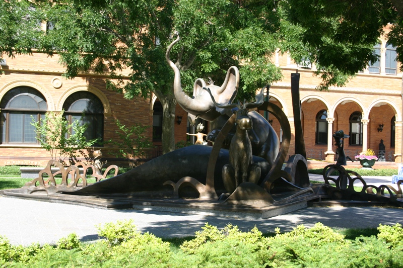 a statue of some animals sitting in front of a building