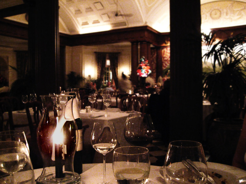 a restaurant dining table with many empty wine glasses on top of it