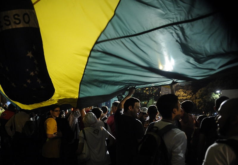 a group of people gathered around an upside down yellow and blue flag