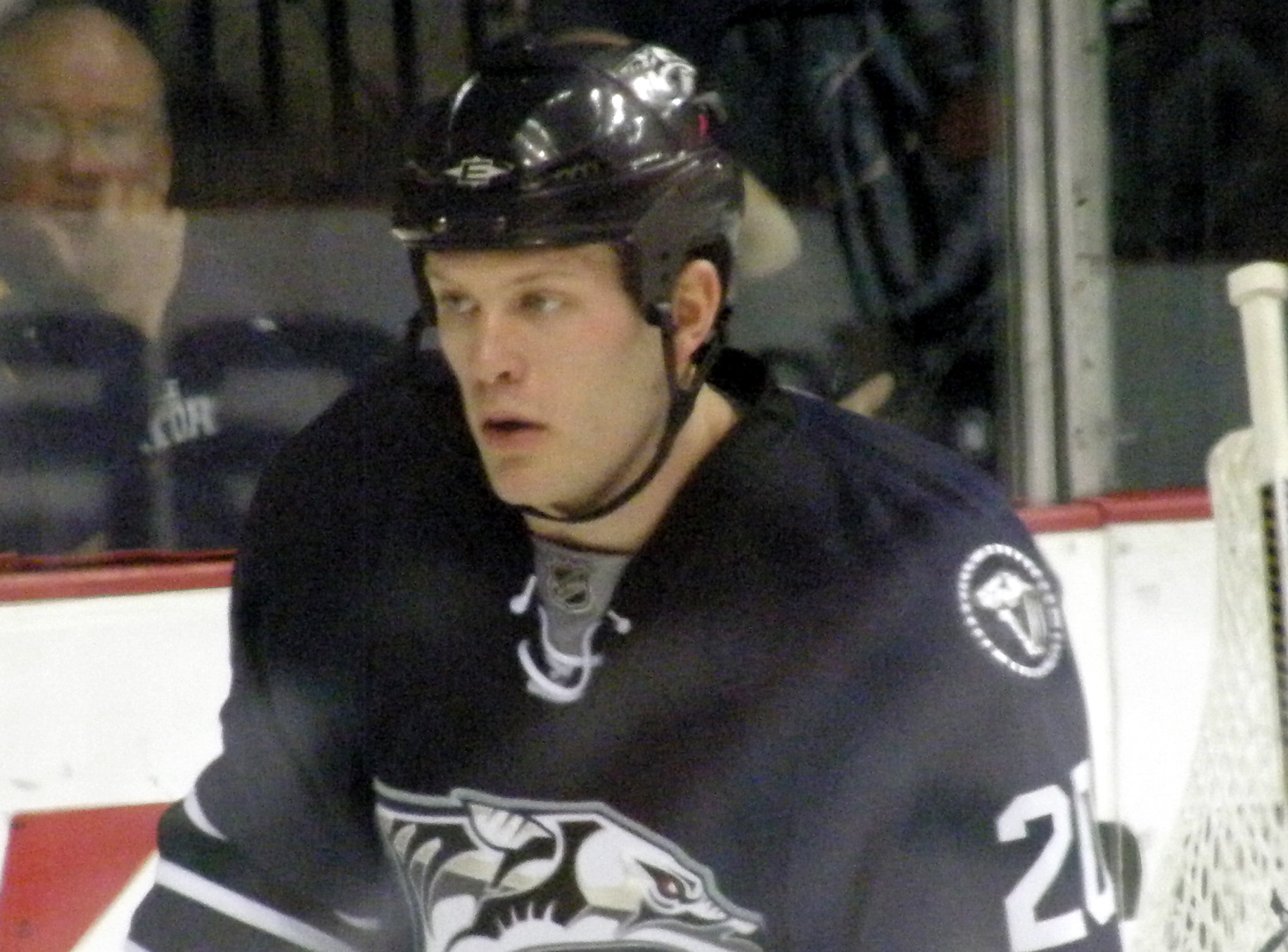 a hockey player wearing black and white standing on the ice