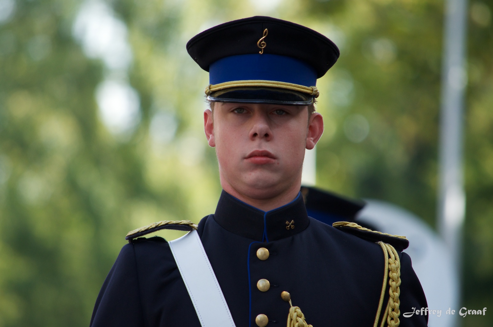a young man in uniform looking serious onlookers