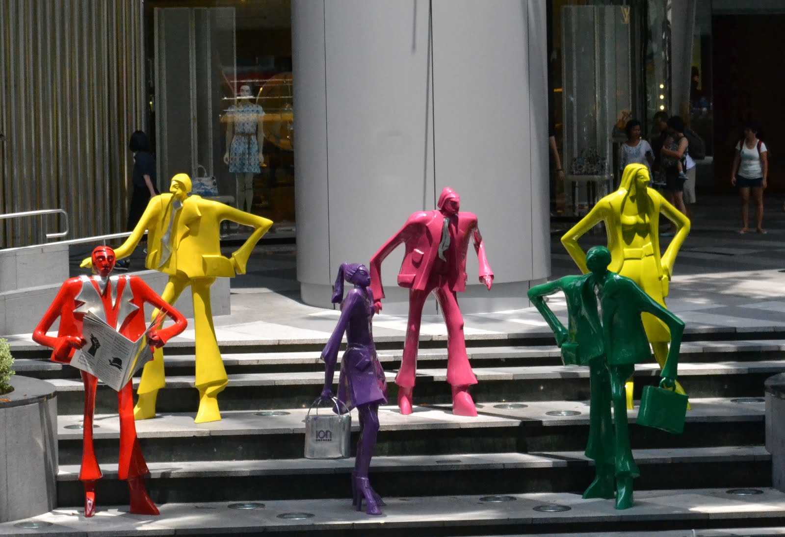 five colorful plastic figures walking down steps on a sunny day