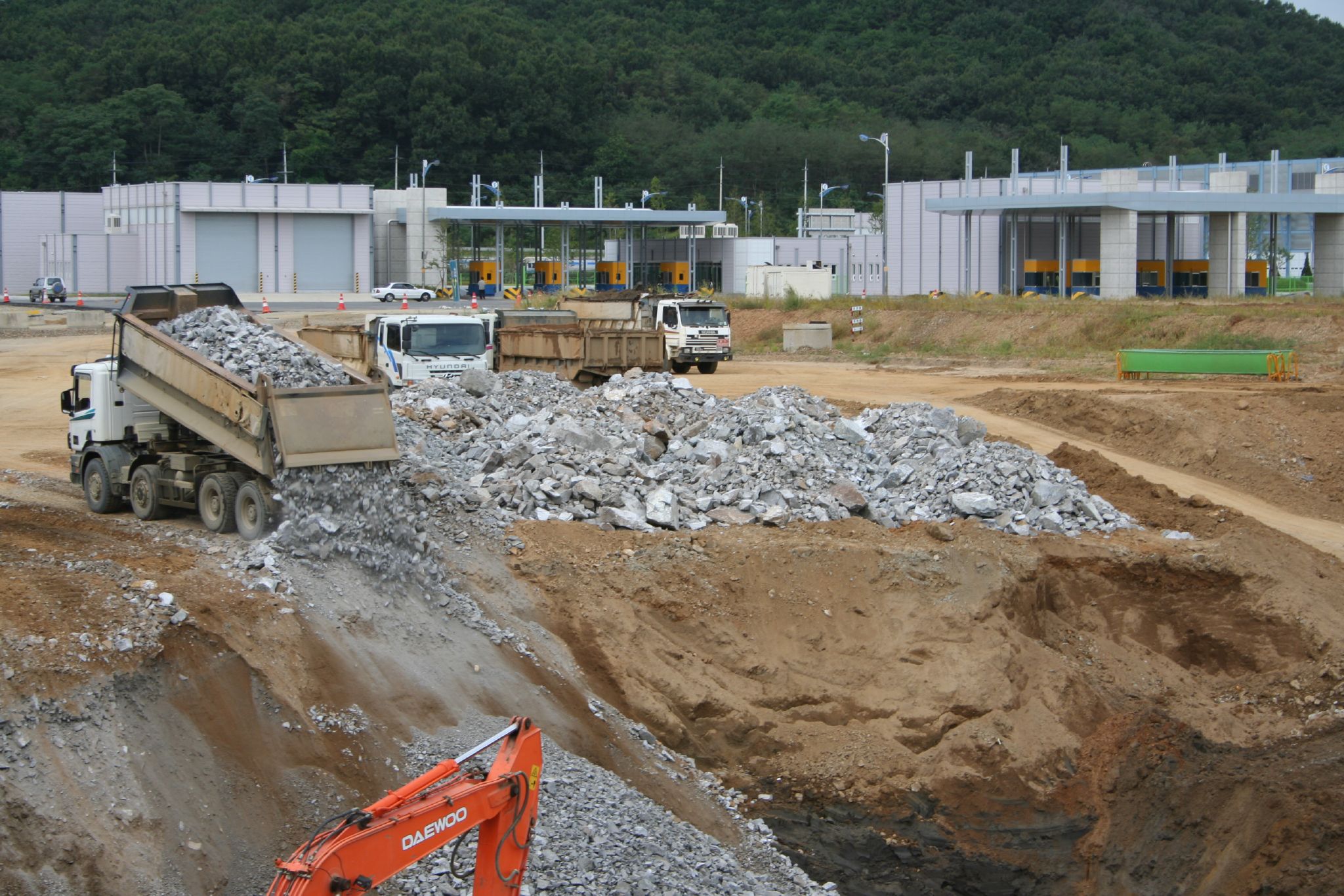 some big trucks and dump trucks in front of some large buildings