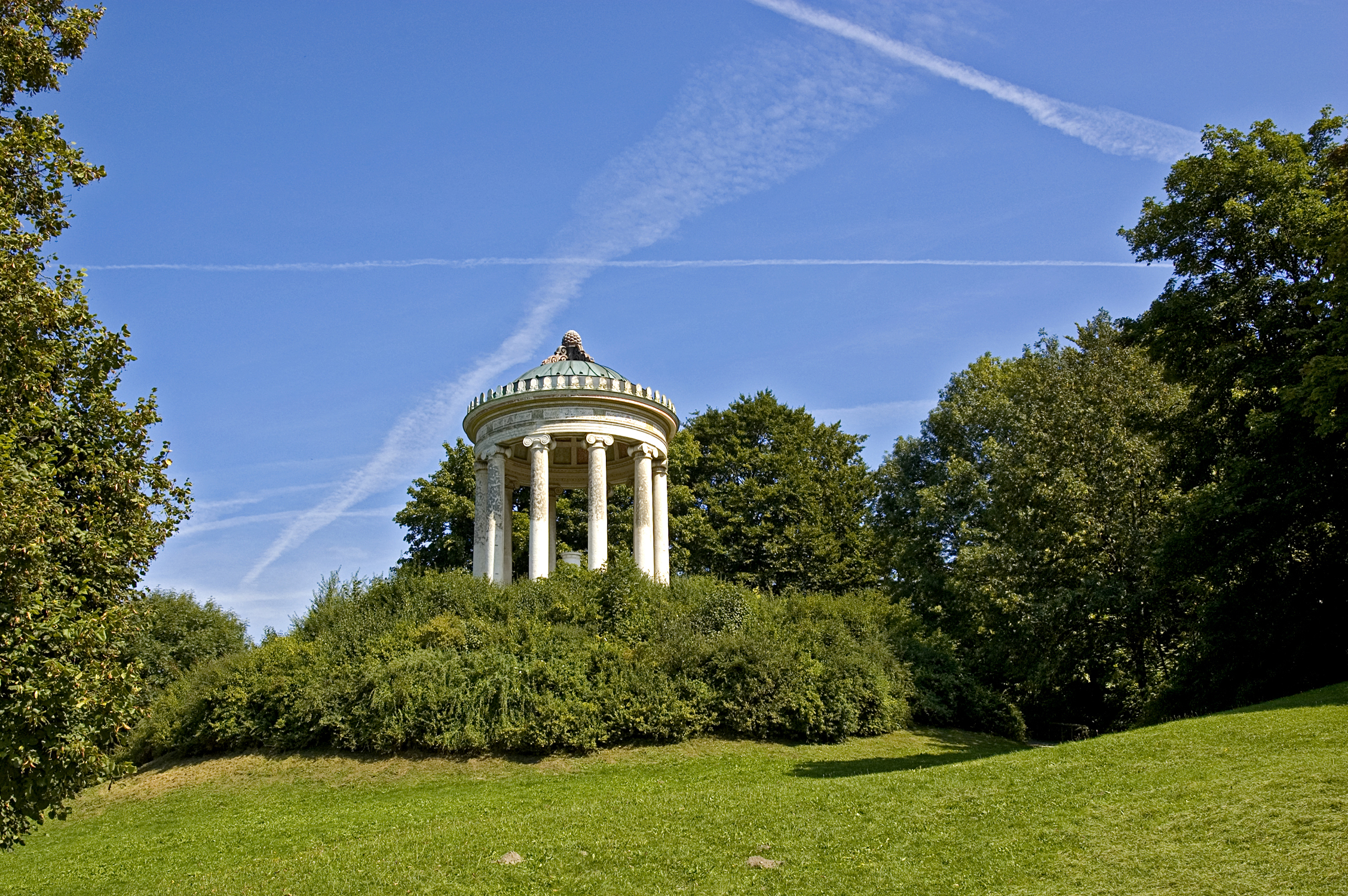 the gazebo at a park with trees surrounding