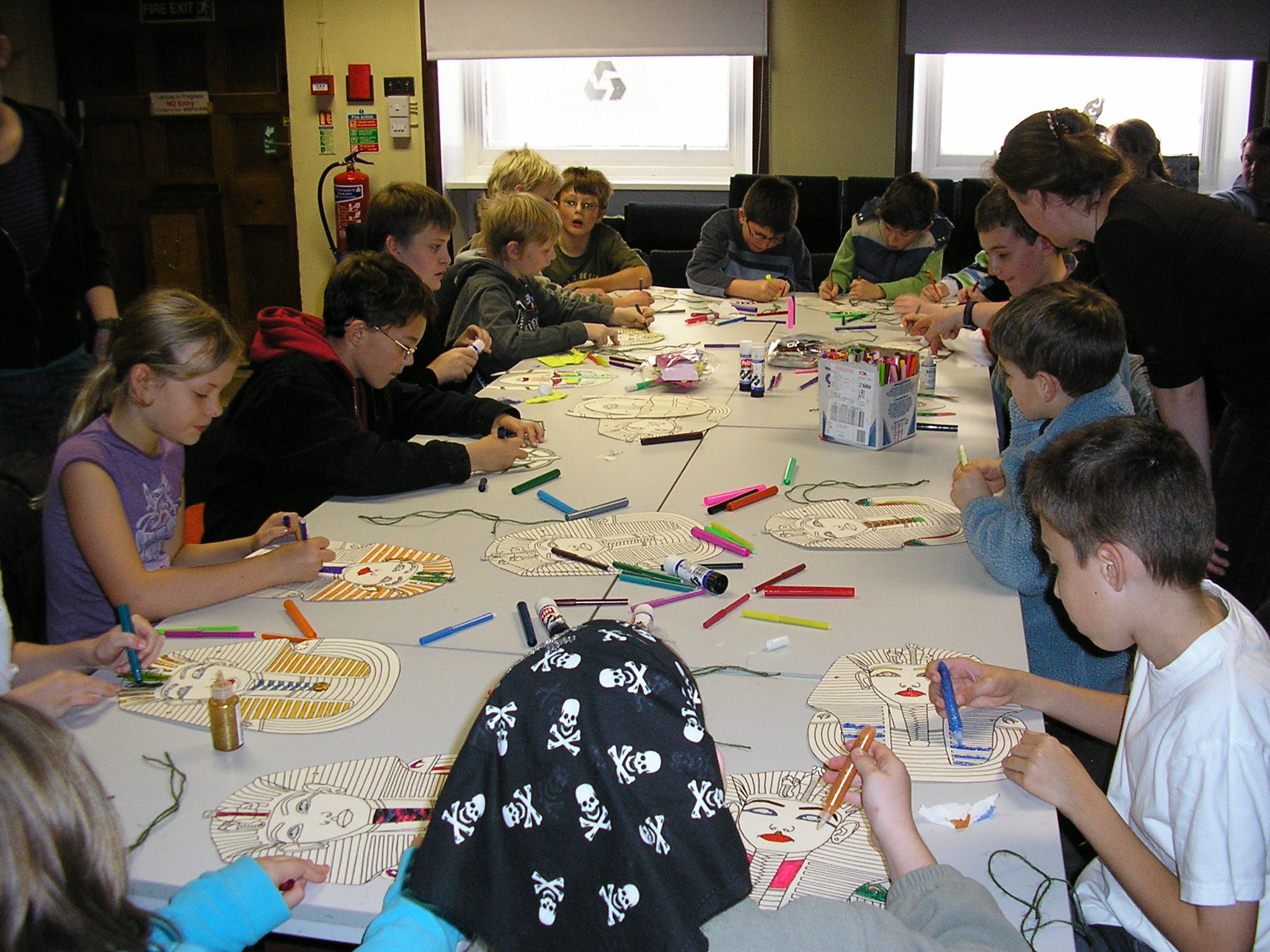 group of s at table making colorful artwork on paper