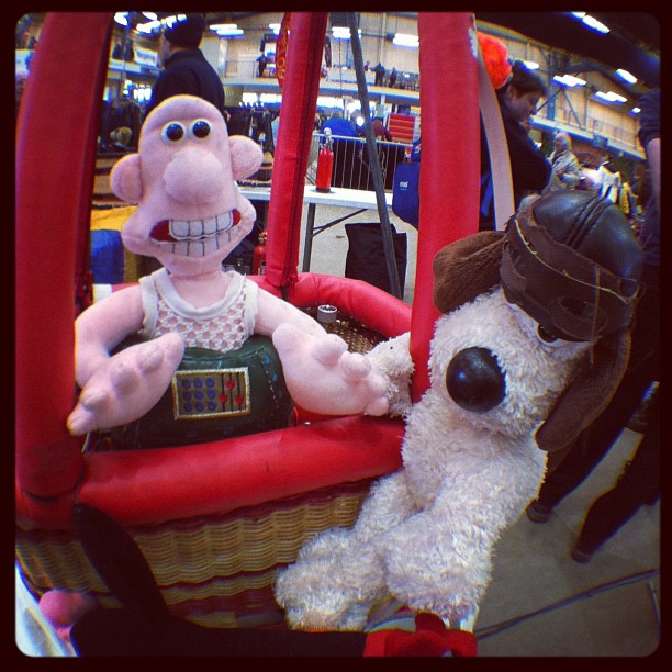 stuffed dogs and a cartoon character play in a carnival