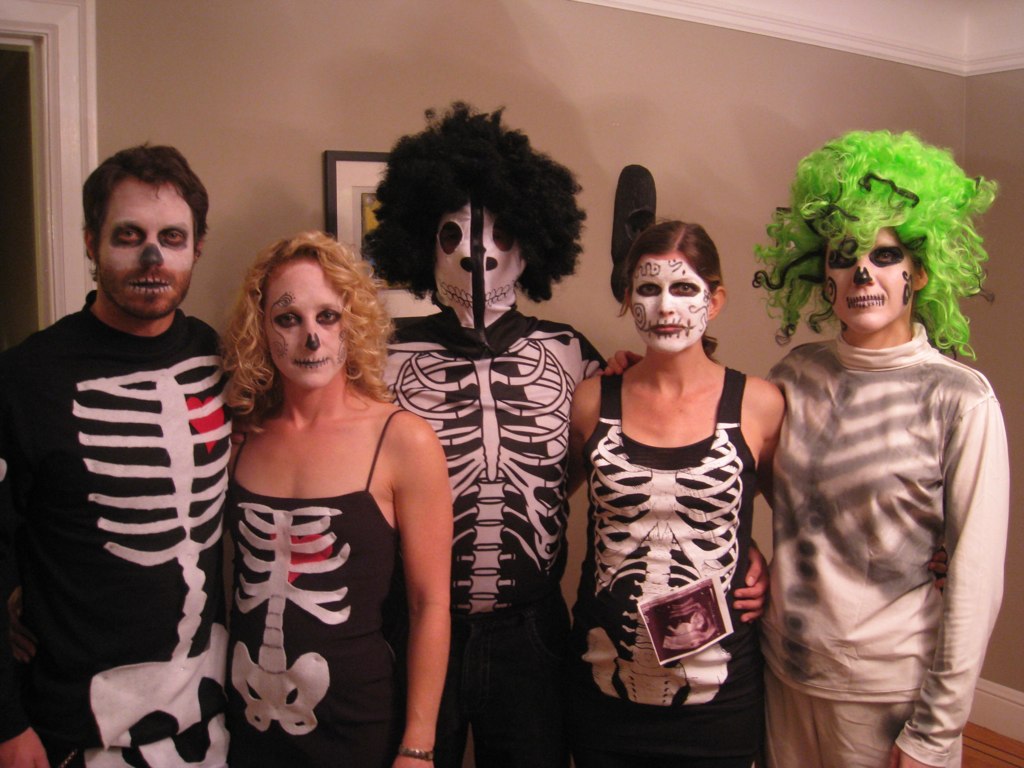 a group of three people dressed in skeleton costumes