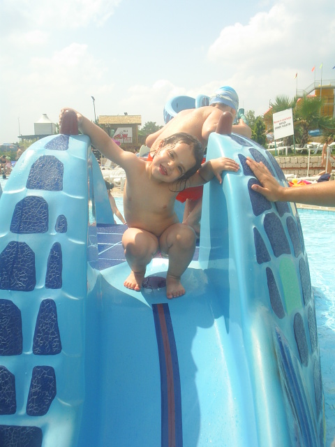 two small children on a blue and green water slide