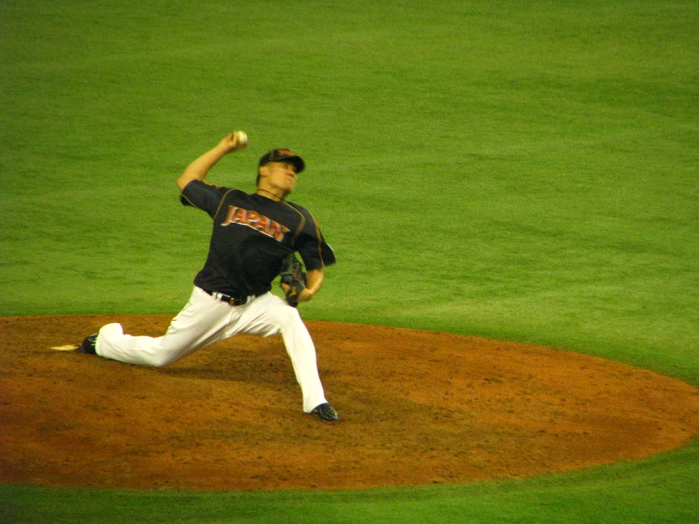 a baseball player winding up to throw a pitch