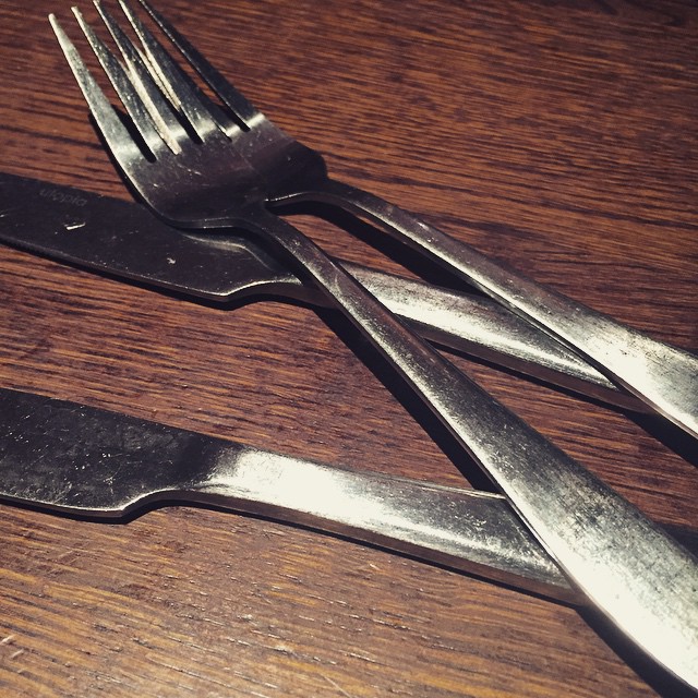 three forks and one knife on a wooden table