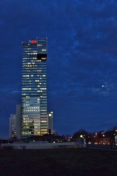 the tall buildings are illuminated up at night