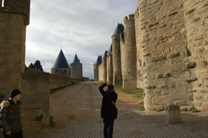 a couple of people standing on a road near many buildings