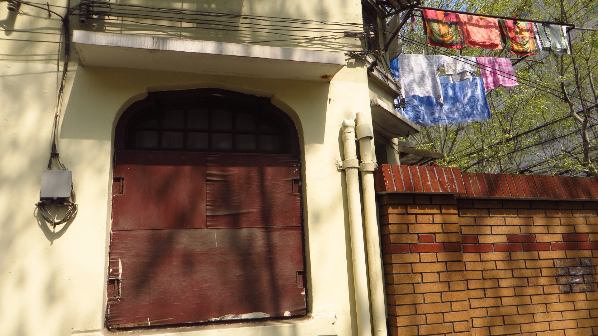 a door with a brick wall and wires in front